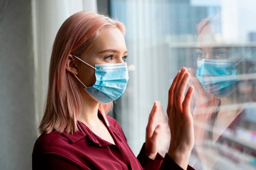 Девушка стоит в медицинской маске